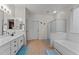 Well-lit bathroom with double vanity, tile floor, separate shower, and soaking tub at 16533 W Carmen Dr, Surprise, AZ 85388