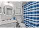 Charming bathroom features a round mirror, a blue striped shower curtain, and a white vanity at 16533 W Carmen Dr, Surprise, AZ 85388