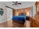 Inviting bedroom featuring a brick wall, sliding barn door to bathroom, and hardwood floors at 16533 W Carmen Dr, Surprise, AZ 85388