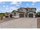 Two-story home with a three-car garage and a well-manicured desert landscape at 16533 W Carmen Dr, Surprise, AZ 85388