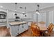 Bright kitchen with white cabinets, a center island, and a wooden dining table at 16533 W Carmen Dr, Surprise, AZ 85388