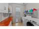 Well-organized laundry room with modern machines, tiled floors, ample counter space, and a doggy door at 16533 W Carmen Dr, Surprise, AZ 85388