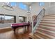 Bright open-plan living room with a pool table, hardwood floors, and staircase at 16533 W Carmen Dr, Surprise, AZ 85388