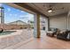 Covered outdoor patio and living area with brick and stone flooring, a ceiling fan, and pool view at 16533 W Carmen Dr, Surprise, AZ 85388