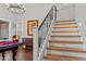 Elegant staircase with wooden steps and iron railings, leads to an upper level with a chandelier at 16533 W Carmen Dr, Surprise, AZ 85388