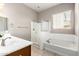 Bathroom features a double vanity, bath tub, and standing shower with tile flooring at 16771 W Adams St, Goodyear, AZ 85338