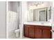 Bright bathroom featuring a wooden vanity and shower-tub combo with floral curtain at 16771 W Adams St, Goodyear, AZ 85338