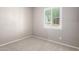 Bedroom features a large bright window with white shutters, neutral carpet and walls at 16771 W Adams St, Goodyear, AZ 85338