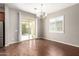 Elegant dining area featuring hardwood floors, a modern chandelier, and access to the outdoor patio at 16771 W Adams St, Goodyear, AZ 85338