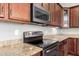 Elegant kitchen featuring granite countertops, stainless steel appliances, and sleek cabinetry at 16771 W Adams St, Goodyear, AZ 85338