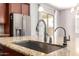 Close-up of the kitchen island featuring a modern faucet and sink, complemented by granite countertops at 16771 W Adams St, Goodyear, AZ 85338