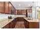 Contemporary kitchen with stainless steel appliances, granite countertops, and rich cabinetry at 16771 W Adams St, Goodyear, AZ 85338
