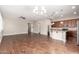 Spacious living room featuring hardwood floors, neutral walls, and an open floor plan connected to the kitchen at 16771 W Adams St, Goodyear, AZ 85338
