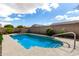 Sparkling blue pool with a safety handrail and stairs nestled in a private backyard at 16771 W Adams St, Goodyear, AZ 85338