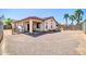Wide open backyard featuring desert landscaping, including palm trees, and a covered patio off the main house at 17008 W Sonora St, Goodyear, AZ 85338