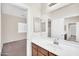 Bright bathroom featuring a single vanity with a large mirror and an open view to a bedroom at 17008 W Sonora St, Goodyear, AZ 85338