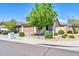 Single-story home featuring a well-manicured lawn, complemented by a shade tree and front yard at 17008 W Sonora St, Goodyear, AZ 85338