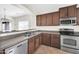 Well-lit kitchen featuring stainless steel appliances, tile floors, and convenient breakfast bar at 17008 W Sonora St, Goodyear, AZ 85338