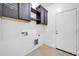 Functional laundry room features tile flooring and plenty of cabinet space at 17008 W Sonora St, Goodyear, AZ 85338