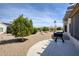The backyard featuring desert landscaping, a grill, and a covered patio, perfect for outdoor enjoyment at 18137 N Plaza Ct, Surprise, AZ 85374