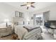 Comfortable bedroom featuring a ceiling fan, window with curtains, and a well-styled bed at 18137 N Plaza Ct, Surprise, AZ 85374