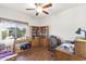Home office with wood flooring, a ceiling fan, and built-in bookshelves at 18137 N Plaza Ct, Surprise, AZ 85374