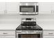 Stainless steel oven and microwave in a white kitchen with white countertops at 18137 N Plaza Ct, Surprise, AZ 85374
