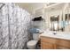 Cozy bathroom featuring a stylish marble shower curtain, chrome shelving, and a classic vanity at 18850 N 16Th Pl, Phoenix, AZ 85024