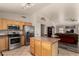 Well-equipped kitchen island and stainless steel appliances open to living room at 18850 N 16Th Pl, Phoenix, AZ 85024