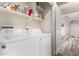 Functional laundry area with white washer and dryer, shelving, and easy access to the rest of the home at 18850 N 16Th Pl, Phoenix, AZ 85024