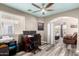 Bright home office featuring a modern desk setup and an adjacent sitting area with a recliner at 18850 N 16Th Pl, Phoenix, AZ 85024