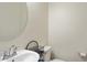 Powder bathroom with round mirror, white sink, and decorative basket at 1924 S 82Nd Cir, Mesa, AZ 85209