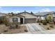 Inviting home featuring a two-car garage, desert landscaping, and a covered entry at 1924 S 82Nd Cir, Mesa, AZ 85209