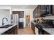 Well-designed kitchen featuring an open pantry, stainless steel appliances, and sleek dark cabinetry at 1924 S 82Nd Cir, Mesa, AZ 85209
