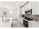 Bright kitchen features white cabinetry, gray backsplash, and stainless steel appliances at 19305 S 209Th Pl, Queen Creek, AZ 85142