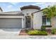 Charming single-story home featuring a gray garage door, a stylish turret entrance, and desert landscaping at 2169 N 212Th Ln, Buckeye, AZ 85396