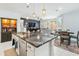Open kitchen featuring a large island, white cabinetry, and a view into the adjoining living and dining areas at 2169 N 212Th Ln, Buckeye, AZ 85396