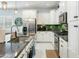 Charming kitchen featuring stainless steel appliances, white cabinets, and sleek countertops and backsplash at 2169 N 212Th Ln, Buckeye, AZ 85396
