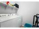 Functional laundry room with washer, dryer, shelving and cleaning supplies at 2169 N 212Th Ln, Buckeye, AZ 85396