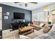 Comfortable living room with a modern entertainment center, a cozy sofa, and plenty of natural light at 2169 N 212Th Ln, Buckeye, AZ 85396