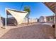 Spacious backyard showcasing a shade sail, gravel landscaping, and additional storage shed at 2581 E Commonwealth Cir, Chandler, AZ 85225