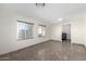 Open living room with tile flooring, two windows letting in lots of light, and access to the laundry room at 2581 E Commonwealth Cir, Chandler, AZ 85225