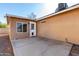 Concrete patio featuring a back door, windows, and tan exterior of a home at 2581 E Commonwealth Cir, Chandler, AZ 85225