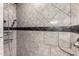 Close-up of a tiled shower with elegant fixtures, shower caddy and a built in shelf at 2581 E Commonwealth Cir, Chandler, AZ 85225
