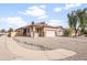 A spacious single-Gathering house showcasing a large front yard with desert landscaping and a two-car garage at 28321 N Zircon Dr, San Tan Valley, AZ 85143