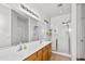 Main bathroom featuring dual sinks, a walk-in shower with glass doors, and a large mirror at 28321 N Zircon Dr, San Tan Valley, AZ 85143
