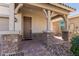 A welcoming front porch features stone pillar bases, brick pavers, and a dark wood front door at 2943 W Thorn Tree Dr, Phoenix, AZ 85085