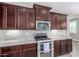 Kitchen with dark wood cabinets and stainless steel appliances at 2943 W Thorn Tree Dr, Phoenix, AZ 85085