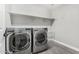 Modern laundry room with gray flooring, a utility sink, and new LG washer and dryer at 2943 W Thorn Tree Dr, Phoenix, AZ 85085