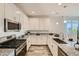 Modern kitchen featuring white cabinets, granite countertops, and stainless steel appliances at 3396 E Open Prairie Dr, San Tan Valley, AZ 85140